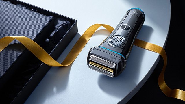 Blue shaver with gold ribbon floating around it